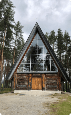 a tall a-frame cabin with the front having many windows